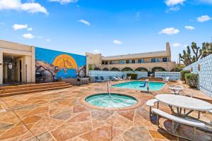 an outdoor patio with a pool and tables and a building at Americas Best Value Inn and Suites -Yucca Valley in Yucca Valley