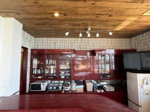 a kitchen with red cabinets and a counter with appliances at 貸別荘 波音と朝日 namine to ASAHI in Miyazu