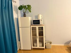 a microwave sitting on top of a refrigerator at エポリスコテージ in Kami Amakusa