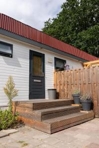 AnlooにあるChalet de Bosrandの木製のデッキと黒いドアのある家