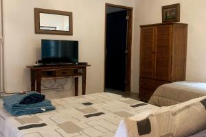 a room with a tv and a bed and a tvicterictericter at Quarto Gaia - Parque Nacional Itatiaia in Itatiaia