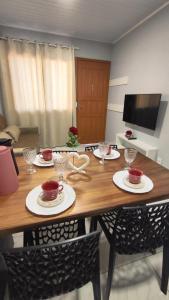 a dining room table with plates and wine glasses at Casa geminada maravilhosa J3 in Santa Cruz do Sul