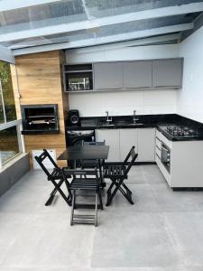 a kitchen with a table and chairs in a room at Apartamento em Governador Celso Ramos in Governador Celso Ramos