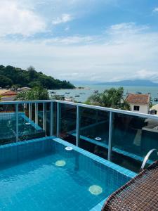 a swimming pool with a view of the ocean at Apartamento em Governador Celso Ramos in Governador Celso Ramos