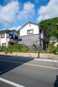 ein weißes Haus am Straßenrand in der Unterkunft 飛梅の宿Tobiume inn in Dazaifu