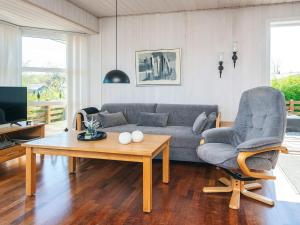 a living room with a couch and a table and a chair at Holiday Home near Loddenhoj Beach in Brøde