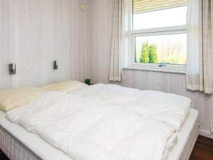 a large white bed in a room with a window at Holiday Home near Loddenhoj Beach in Brøde