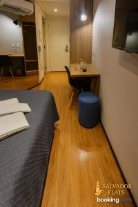 a room with a bed and a desk and a table at Luxo e Comodidade Sentin Sao Luiz in Sao Paulo