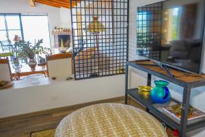 Una habitación con una mesa y un jarrón azul en un estante. en Cabin with Jacuzzi View with Fireplace, en El Retiro