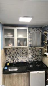 a small kitchen with a sink and a stove at Hian's Place 01 in Foz do Iguaçu