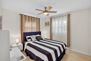 セント・ピーターズバーグにあるAzure Hideaway w Private Heated Pool, 8 Min to St Pete Beachのベッドと天井扇風機のある寝室