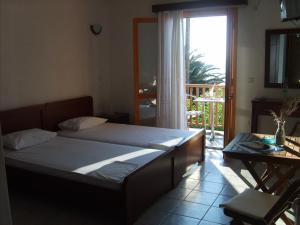 a bedroom with a bed and a table and a window at Τo Κamari in Skiros