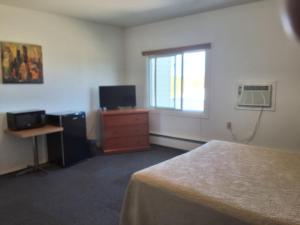 a bedroom with a bed and a dresser and a window at Wildwood Hotel in Wildwood