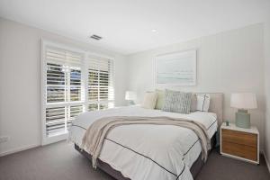 a white bedroom with a large bed and a window at Casa del Sol Heated Pool & Spa in Sorrento