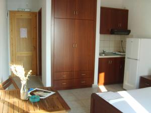 a kitchen with wooden cabinets and a table in a room at Τo Κamari in Skiros