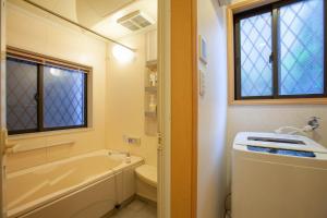 a bathroom with a tub and a toilet and a sink at Lucky Higashi Mizue - Vacation STAY 16180 in Tokyo +32 photos