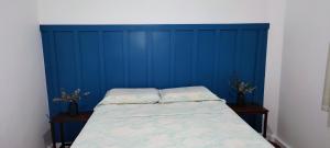 Bett in einem Zimmer mit blauer Wand in der Unterkunft Brazil Cozy and Comfortable in Rio de Janeiro