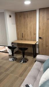 a room with a table and two stools and a couch at Edificio Living 42 - Apto 105 in Estación El Salto