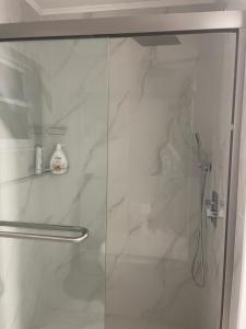una ducha con puerta de cristal en un baño en 海湾景观休闲独立屋可以垂钓靠近达利博物馆 14分钟可到达, en San Petersburgo