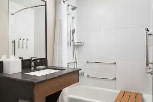 a bathroom with a sink and a tub and a mirror at Fairfield Inn and Suites Sacramento Airport Natomas in Sacramento