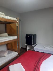 a room with three bunk beds and a suitcase at Pousada Village Hostel in Petrópolis +32 photos