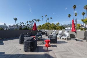 a patio with chairs and tables and red umbrellas at Hollywood Stars Walk of Fame Apartment in Los Angeles