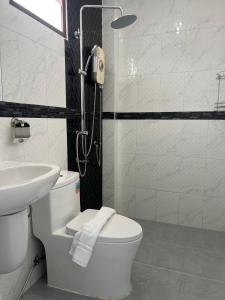 a bathroom with a toilet and a sink and a shower at J2 Airport Mansion in Thalang