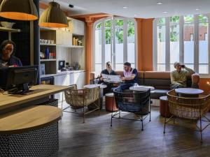 a group of people sitting at a table in a library at ibis Paris Tour Montparnasse 15eme in Paris