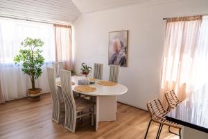 a dining room with a white table and chairs at Hot Tub, Ice Bath, Gym, Sauna, Pool Table Coorparoo Haven in Brisbane +49 photos