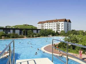 a large swimming pool with people in it at Mercure Hotel Bad Duerkheim An Den Salinen in Bad Dürkheim