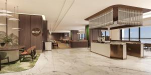 a lobby of a hotel with tables and chairs at Hilton Garden Inn Lanzhou Anning in Lanzhou