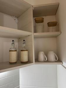 four glass jars are sitting on shelves in a kitchen at Departamento Bonito Excelente Ubicación in Morón