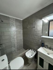 a bathroom with a white toilet and a sink at Departamento Bonito Excelente Ubicación in Morón