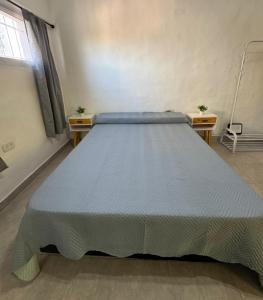a large bed in a room with two tables at Departamento Bonito Excelente Ubicación in Morón