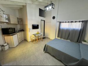 a bedroom with a bed and a small kitchen at Departamento Bonito Excelente Ubicación in Morón