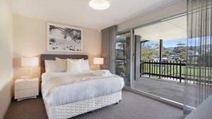 a bedroom with a bed and a sliding glass door at Surf N Turf in Kiama +34 photos