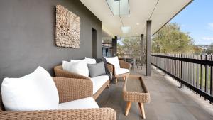 a balcony with white couches and chairs on it at Surf N Turf in Kiama