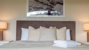 1 dormitorio con 1 cama con 2 lámparas en Surf N Turf - The Grandstand, en Kiama