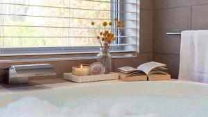 Un baño con bañera con libros y una ventana. en Surf N Turf - The Grandstand, en Kiama 23 fotos más