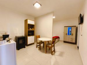 a room with a kitchen and a table and chairs at Estúdios VILA 5 Hotel, próximo a Praça dos Três Poderes in Brasilia