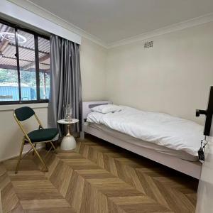 una camera da letto con un letto, una sedia e una finestra di Modern Vintage King and Single Rooms a Bankstown Altre 34 foto