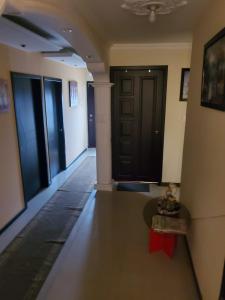 a hallway with black doors and a table in a room at En Tulcán, habitaciones amobladas in Tulcán