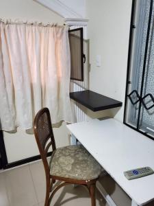 a table and a chair in a kitchen with a window at En Tulcán, habitaciones amobladas in Tulcán