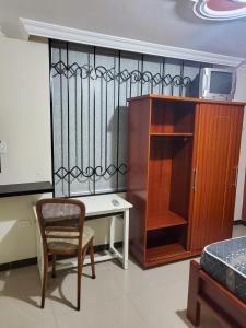 a room with a desk and a chair and a cabinet at En Tulcán, habitaciones amobladas in Tulcán
