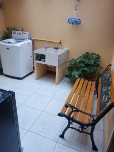 a bench in a room with a refrigerator and a sink at En Tulcán, habitaciones amobladas in Tulcán