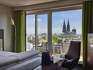 a hotel room with a bed and a view of a city at Pullman Cologne in Cologne +95 photos