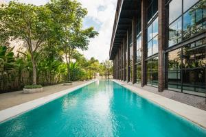 a swimming pool in front of a building at ONYX PARK RESORT Ubud in Ubud +17 photos