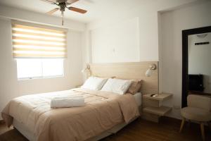 Un dormitorio con una cama y una silla y una ventana. en Amplio y Familiar 3BR de 3 pisos. Smart Home, en Lima
