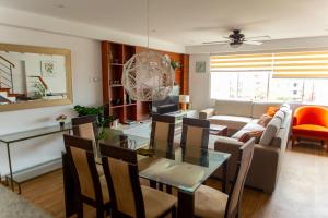 Un comedor y una sala de estar con mesa y sillas. en Amplio y Familiar 3BR de 3 pisos. Smart Home, en Lima