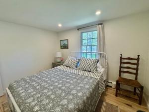 a bedroom with a bed and a chair and a window at The Brewster Pearl in Brewster